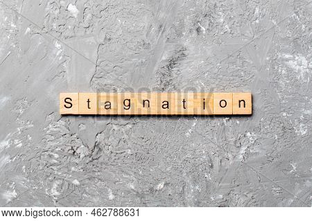Stagnation Word Written On Wood Block. Stagnation Text On Cement Table For Your Desing, Concept.