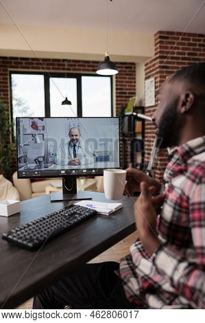 African American Man Chatting With Medic On Telemedicine Videocall Conference, Using Online Teleheal