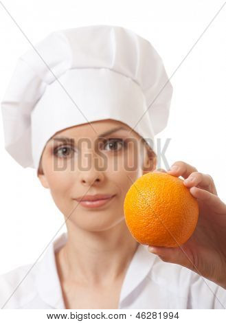 Smilende kvinde cook med orange, isoladed på hvid baggrund