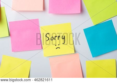 Sticky Note With Inscription Sorry Between Other Colorful Notes On A Whiteboard