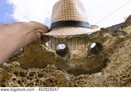 The Top Of The Cliff In The Form Of A Smiling Face With Eyes And A Mouth And A Hat. Texture, Weather