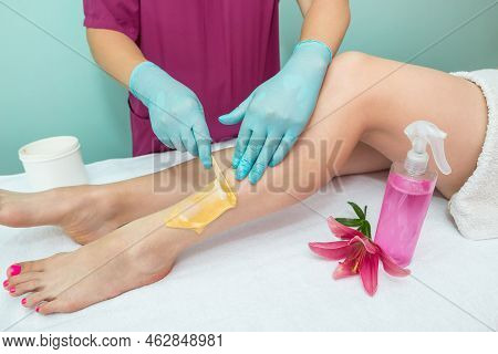 Leg Sugaring. A Beautician Makes A Sugar Paste Depilation Of A Woman's Legs In A Beauty Salon. Femal