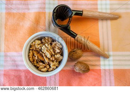 Cracking Walnuts On The Orange Napking Table, Top View