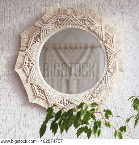 Macrame Mirror On A White Wall.  The Mirror Reflects Macrame Wallhanging. Eco-style. Natural Materia
