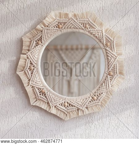 Macrame Mirror On A White Wall.  The Mirror Reflects Macrame Wallhanging. Eco-style. Natural Materia