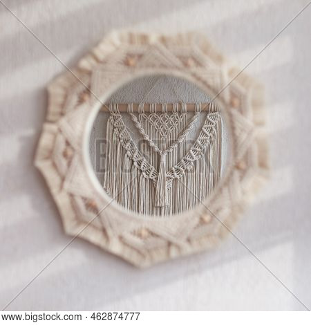 Macrame Mirror On A White Wall.  The Mirror Reflects Macrame Wallhanging. Eco-style. Natural Materia