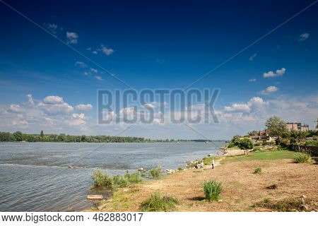 Slankamen, Serbia - June 12, 2022: People Standing On A Beach On The Riverbank Of The Danube River W