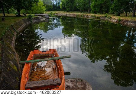 Panorama Of An Abandoned Half Sunken Rowing Boat, An Orange Small Boat, Resting In The Neglected Pon