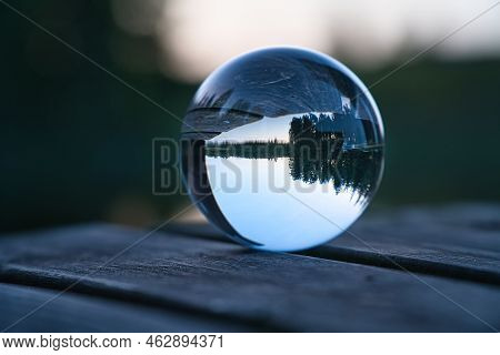 Glass Ball On A Wooden Pier At A Swedish Lake At Evening Hour. Nature Shot From Scandinavia