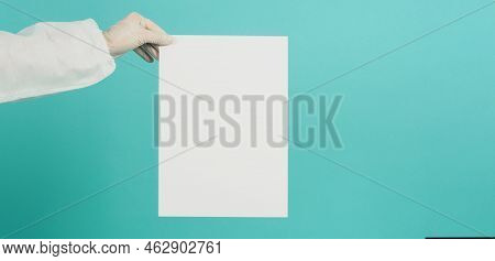 Blank Paper Board Inhand With White Latex Glove Andppe Suit On Green Mint Or Tiffany Blue Background