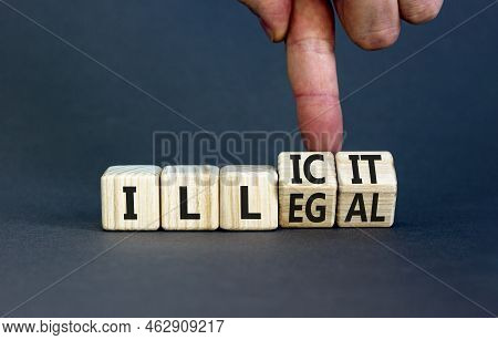 Illegal Or Illicit Symbol. Businessman Turns Wooden Cubes And Changes The Concept Word Illegal To Il