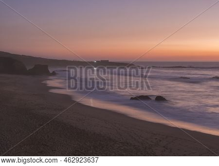 Mysterious Long Exposure View Of Sand Beach Praia Grande De Almograve With Blurred Ocean Waves In Pi
