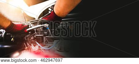 The Red Gloved Hand Of The Auto Mechanic Is Fastening The Bolt With The Socket Wrench To Fix The Veh