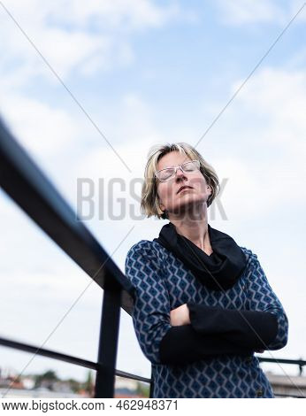 Portrait Of An Attractive Thirty Year Old Woman Posing On A Terrace, Eyes Closed