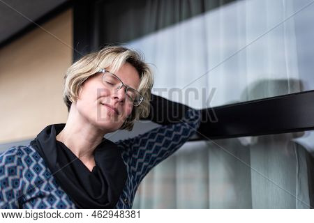 Portrait Of An Attractive Thirty Year Old Woman Posing On A Terrace, Eyes Closed, Brussels, Belgium