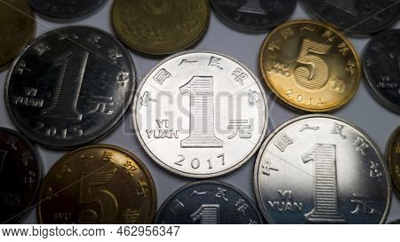 Lots Of Chinese Coins, One Chinese Yuan In The Center. A Close-up Shot Of A 1 Yuan Coin. In The Back