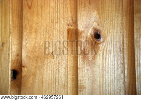 Part Of A Wooden Wall Made Of Lining. Several Planks Are Nailed To The Wall Vertically Next To Each 