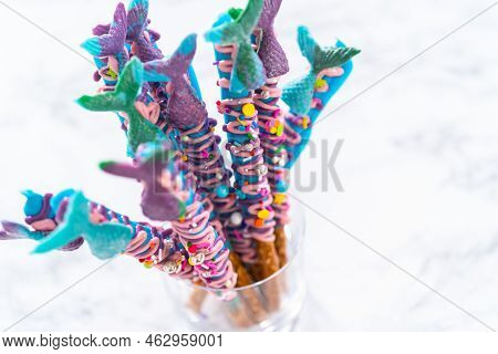 Mermaid Chocolate Pretzel Rods Drizzled With Pink And Purple Chocolate And Covered With Sprinkles.