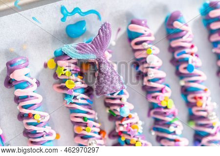 Mermaid Chocolate Pretzel Rods Drizzled With Pink And Purple Chocolate And Covered With Sprinkles.