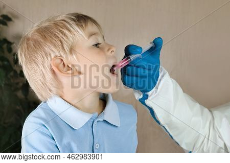 Kid Getting Polio Drops. Doctor Making To Child Oral Vaccination Against Infection. Little Blonde Ha