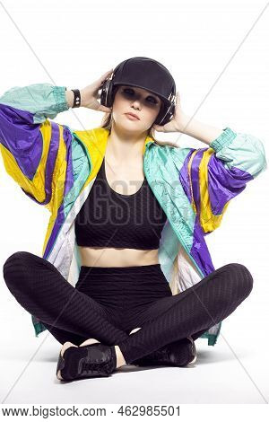 Closeup Portrait Of Young Caucasian Female  Sportwoman In Fitness Outfit And Baseball Cap With Wirel
