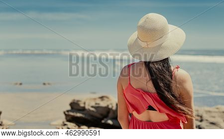 Back View Of Girl With Hat Looking At The Sea, Young Woman In Hat Looking At The Sea On Vacation, Co