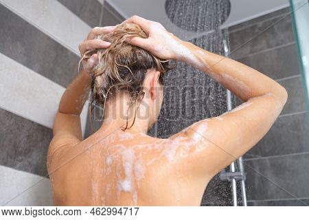 Young Woman Washes Her Hair With Shampoo And Hands With Foam Closeup. Back Of Beautiful Woman Taking