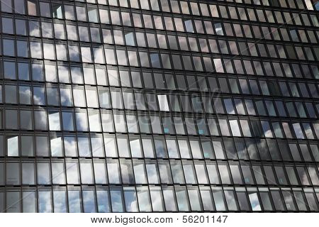 Cloudy sky reflects in a glassy house front