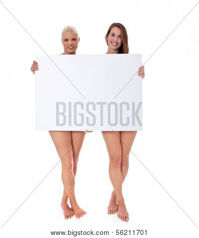 Full length shot of two barely clothed attractive women behind blank white sign. All on white background.