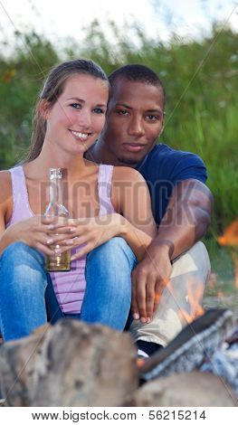 Couple enjoys time at camp fire.