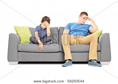 Dissappointed brothers sitting on a sofa isolated on white background