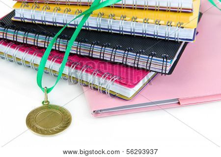 Medal for achievement in education and notebooks close up
