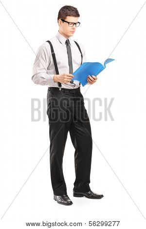 Full length portrait of young man reading papers, isolated on white background