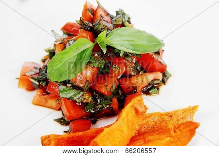 vegetable salad : cherry tomatoes and basil with sweet baked potato served on white plate with sauceboat full blask soy sauce on wood