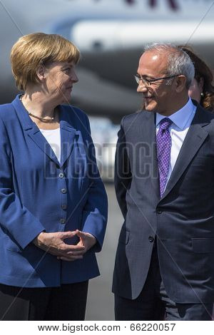BERLIN, GERMANY - MAY 20, 2014: German Chancellor Angela Merkel (L) and Turkish Minister of transport Lutfi Elvan (R) open up the International aviation and space exhibition ILA.