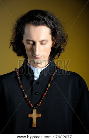 Fogalmi portré fakereszttel pap imádkozott. Sárga háttérrel