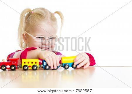 Child in eyeglasses playing toy train isolated  on white