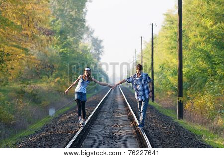 Teen Girl And Boy Walking On Rails
