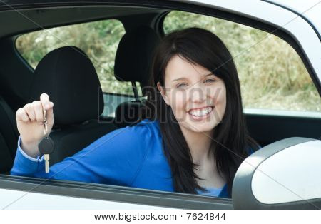 Jolly Teen pige sidder i hendes bil og holde tasterne