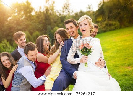 Newlyweds with guest posing in park