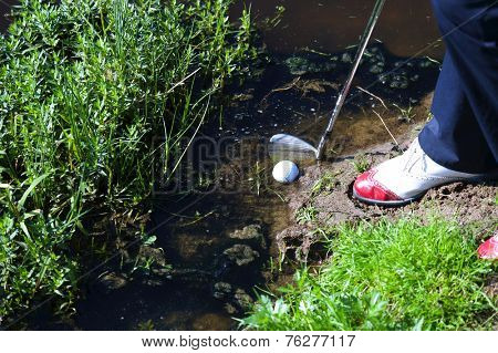 Man chipping ball from water hazard