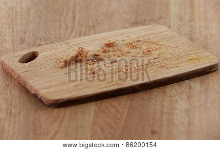 Bread crumbs on cutting board on wooden background