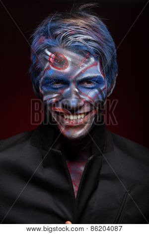 A creepy portrait of a halloween man with face art.