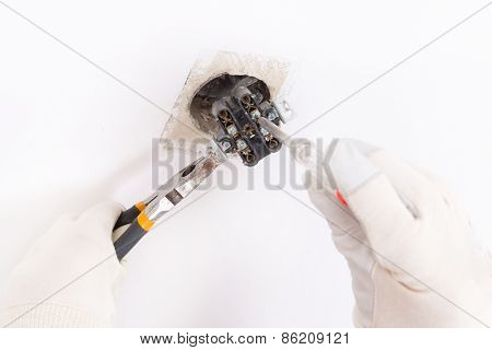 Electrician replacing old socket with pilers and screwdriver