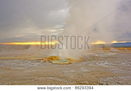 Geyser Erupting At Sunset