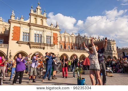 KRAKOW, POLAND - JUL 11, 2015: Participants at the annually (July 9-12) 28th International Festival of Street Theatres - Orchestre International du Vetex (Belgium/France) in the Main Square of Krakow.