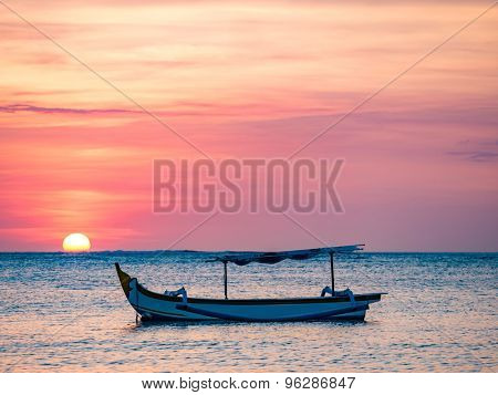 traditional Balinese ships Jukung close on Sanur beach at sunrise, Bali, Indonesia