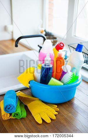 Basket With Cleaning Items On Blurry Background White Citchen. Cleaning Concept.