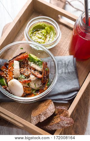 Salad sauce avocado cranberry drink in a wooden box vertical