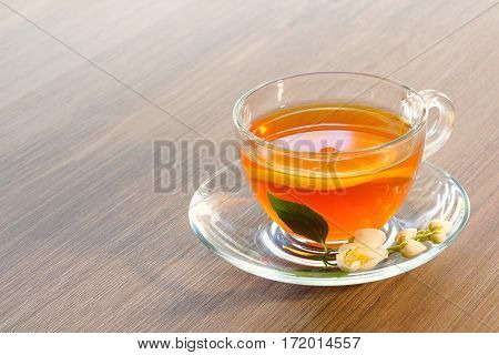 Tea with lemon and jasmine flowers on a wooden table